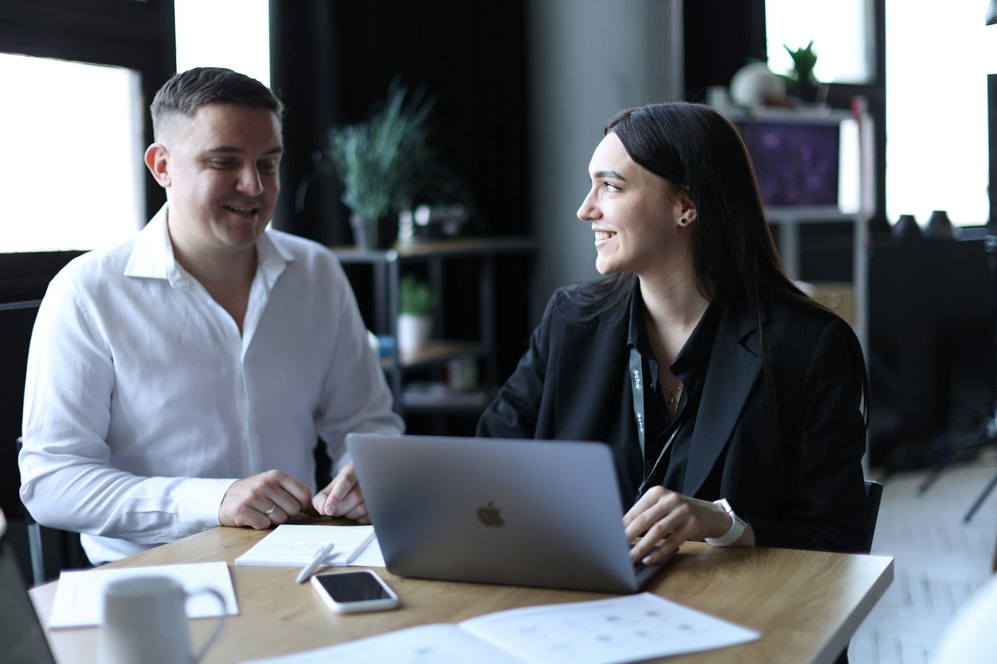 Two people reviewing information on a laptop at a table